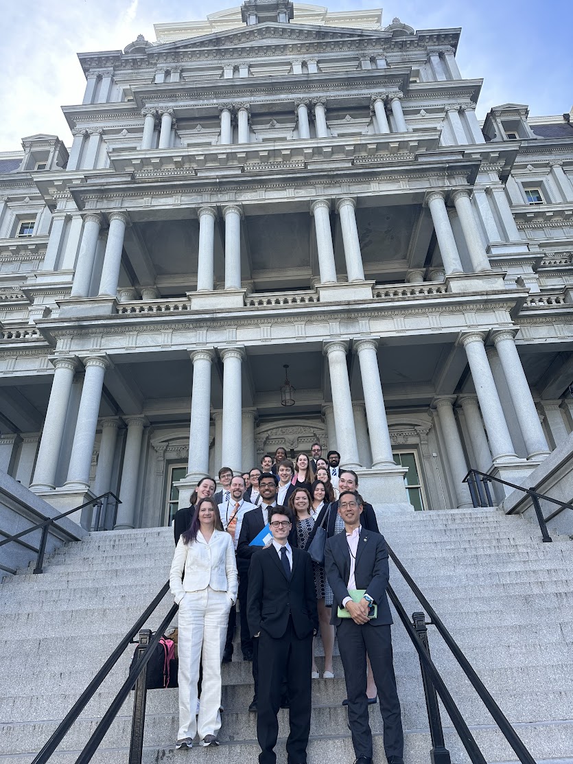 Group photo of CVD volunteers and OSTP members standing on the Navy Steps at the Eisenhower building.