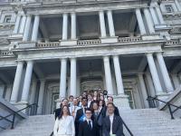 Group photo of CVD volunteers and OSTP members standing on the Navy Steps at the Eisenhower building.